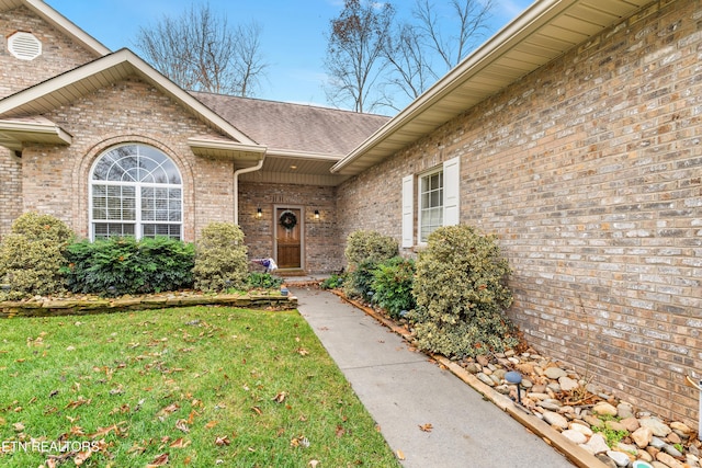 view of exterior entry with a yard