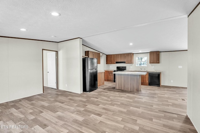 kitchen with a textured ceiling, black appliances, a center island, light wood-type flooring, and crown molding