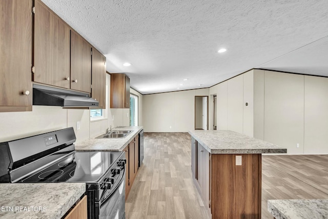 kitchen featuring stainless steel electric stove, a textured ceiling, a kitchen island, light hardwood / wood-style flooring, and sink