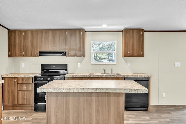 kitchen featuring a kitchen island, black appliances, sink, crown molding, and light wood-type flooring