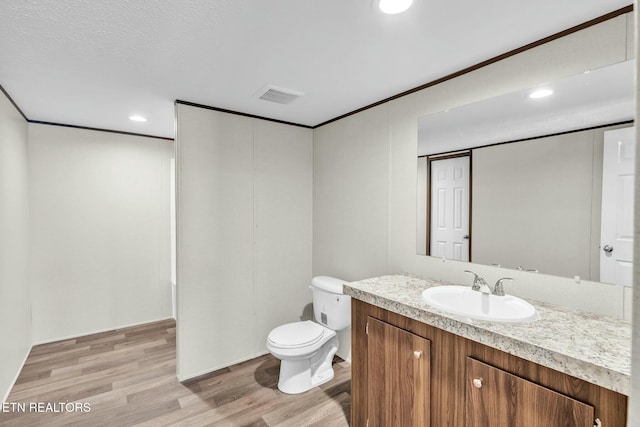 bathroom featuring toilet, wood-type flooring, and vanity