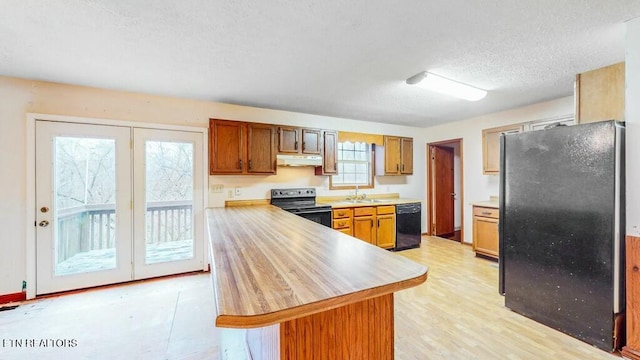 kitchen with a textured ceiling, sink, a wealth of natural light, and black appliances