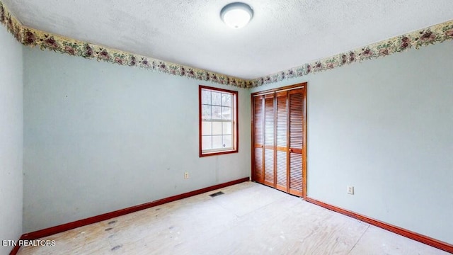 unfurnished room featuring a textured ceiling