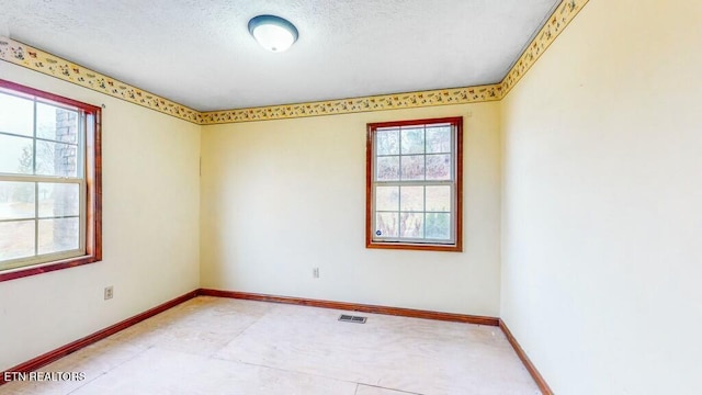 unfurnished room with a textured ceiling