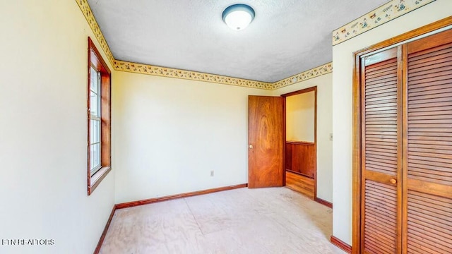 unfurnished bedroom featuring multiple windows, a textured ceiling, and a closet