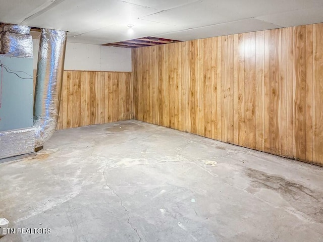 basement featuring wood walls