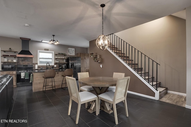 dining space featuring ceiling fan with notable chandelier and sink