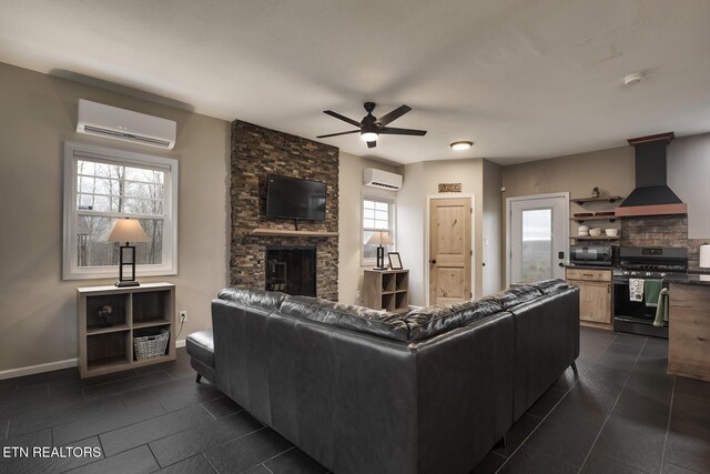 tiled living room with a stone fireplace, a wall mounted AC, and ceiling fan