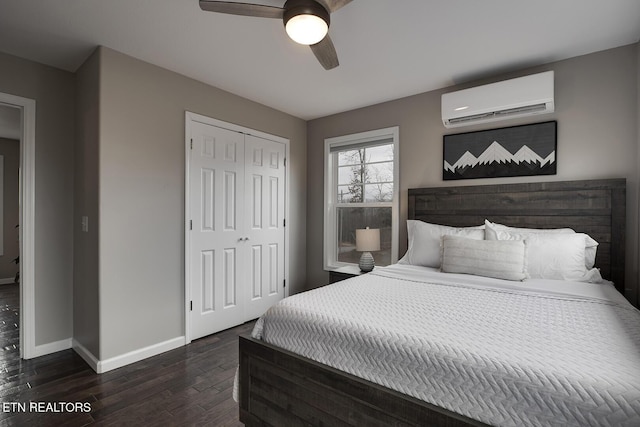 bedroom featuring dark hardwood / wood-style floors, a closet, a wall mounted AC, and ceiling fan