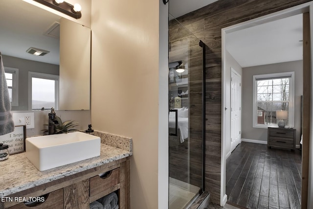 bathroom featuring vanity, an enclosed shower, and wood-type flooring