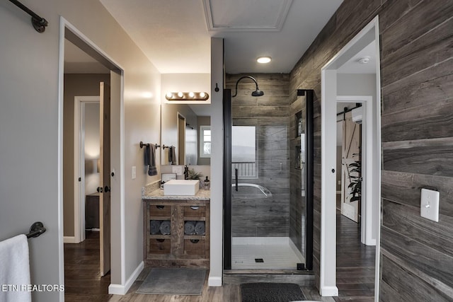 bathroom featuring a shower with door, vanity, and wood-type flooring