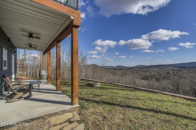 view of yard with a mountain view, a patio, and ceiling fan