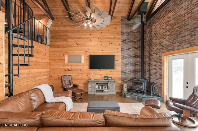 living room with beamed ceiling, high vaulted ceiling, wood walls, and wood ceiling