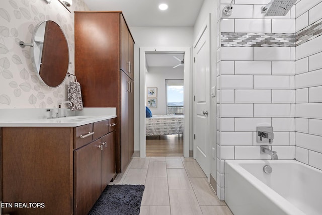 bathroom featuring hardwood / wood-style flooring, vanity, and tiled shower / bath