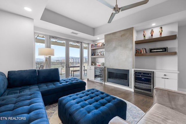 living room featuring dark hardwood / wood-style floors, ceiling fan, a fireplace, and wine cooler