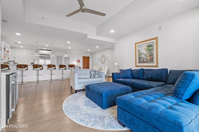 living room featuring wine cooler, ceiling fan, sink, and dark hardwood / wood-style floors