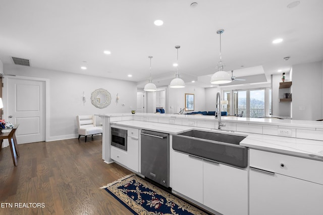 kitchen featuring ceiling fan, light stone countertops, white cabinetry, and dark wood-type flooring