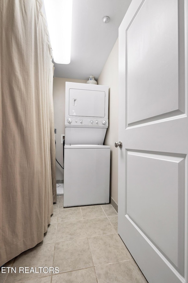 laundry room with light tile patterned floors and stacked washer and clothes dryer