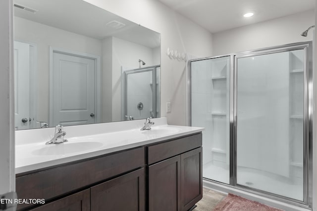 bathroom featuring wood-type flooring, vanity, and a shower with shower door