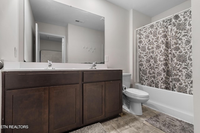 full bathroom featuring shower / bath combo with shower curtain, vanity, and toilet