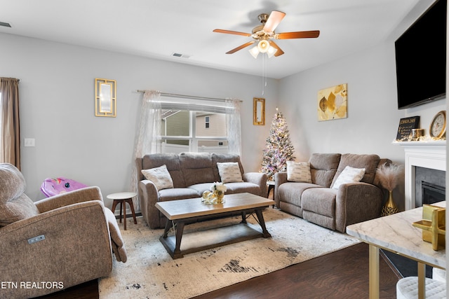 living room with ceiling fan and dark hardwood / wood-style flooring