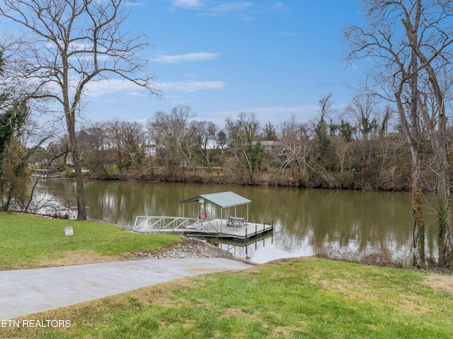 view of dock featuring a lawn and a water view