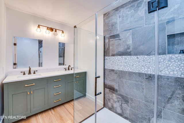 bathroom featuring hardwood / wood-style flooring, vanity, and an enclosed shower