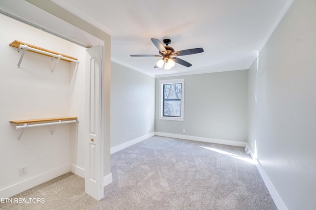 unfurnished bedroom featuring ceiling fan, crown molding, light carpet, and a closet