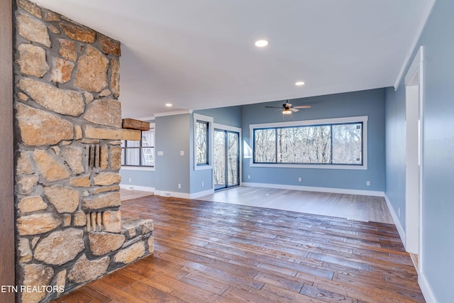 unfurnished living room with ceiling fan and wood-type flooring