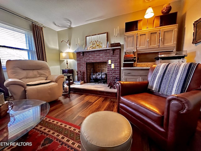 sitting room featuring hardwood / wood-style flooring and a brick fireplace