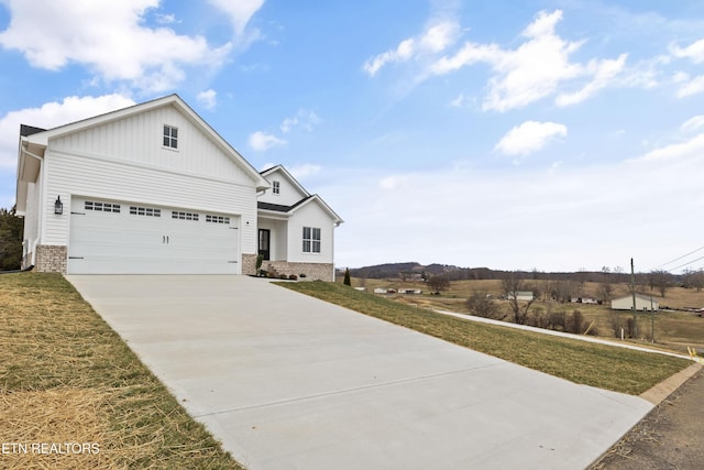 view of front of property featuring brick siding, driveway, a front lawn, and board and batten siding