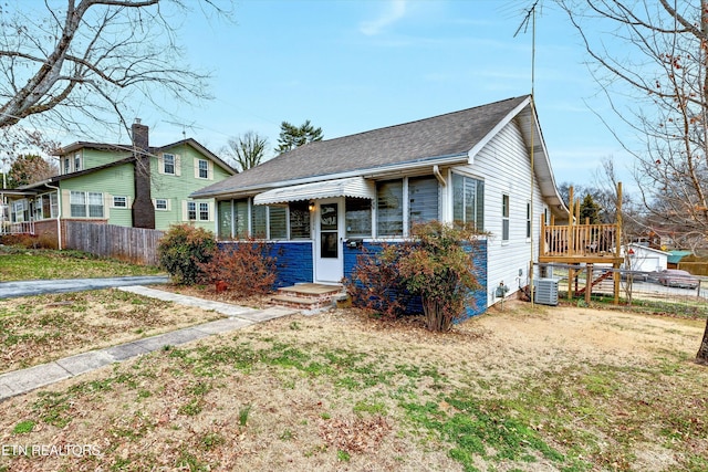 bungalow-style home featuring a shingled roof, fence, and cooling unit