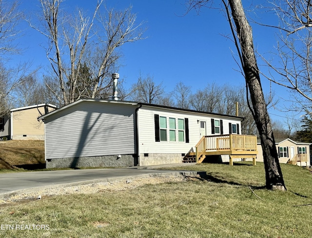 manufactured / mobile home featuring a front lawn and a deck