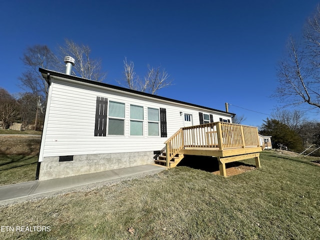 back of property featuring a wooden deck and a yard