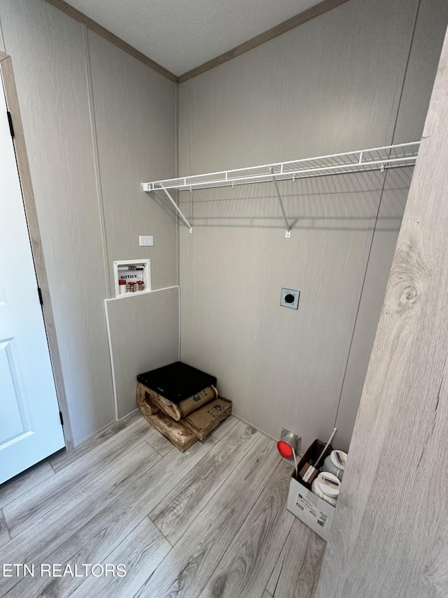 clothes washing area featuring hookup for an electric dryer, washer hookup, ornamental molding, and light hardwood / wood-style flooring