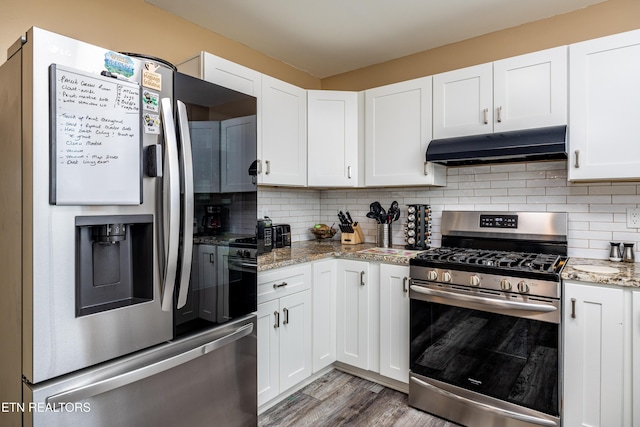 kitchen featuring decorative backsplash, light stone counters, white cabinets, and appliances with stainless steel finishes