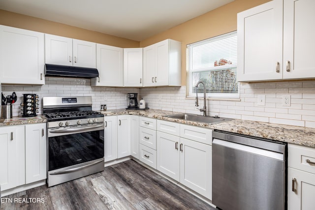 kitchen with sink, dark hardwood / wood-style floors, appliances with stainless steel finishes, light stone counters, and white cabinetry