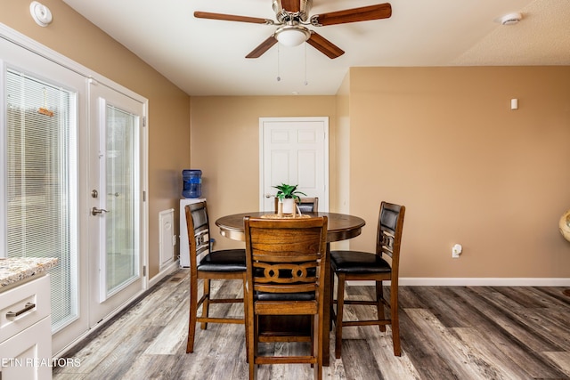 dining room featuring ceiling fan, wood-type flooring, and a wealth of natural light