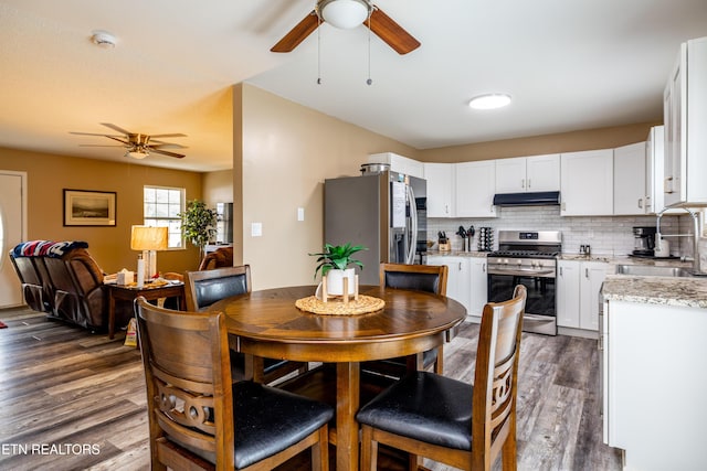 dining room featuring ceiling fan, sink, and dark hardwood / wood-style floors