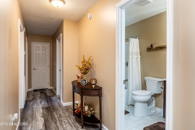 corridor featuring hardwood / wood-style floors and a textured ceiling