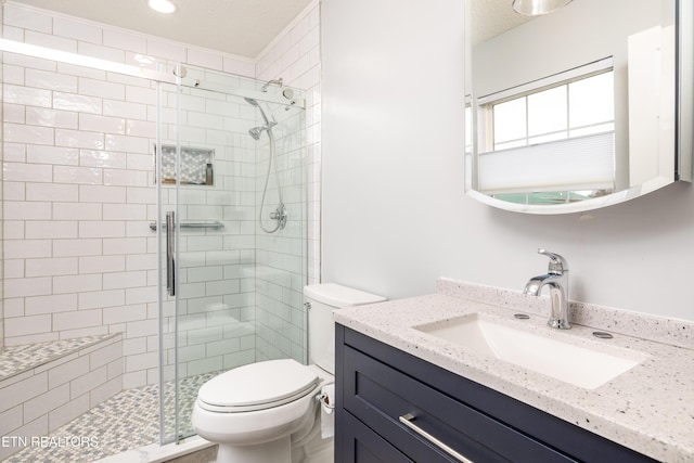 bathroom featuring vanity, a shower with shower door, and toilet