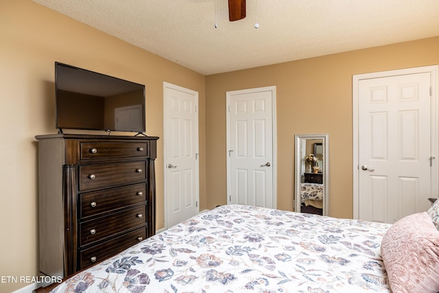 bedroom with ceiling fan and a textured ceiling