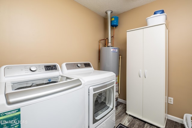 laundry room featuring cabinets, a textured ceiling, gas water heater, dark wood-type flooring, and washer and dryer