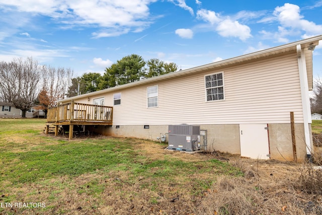 rear view of house featuring a yard, a deck, and central air condition unit