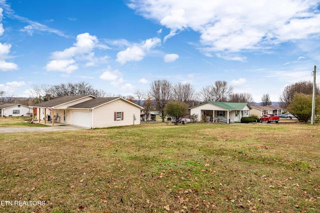 view of side of home featuring a garage, covered porch, and a yard