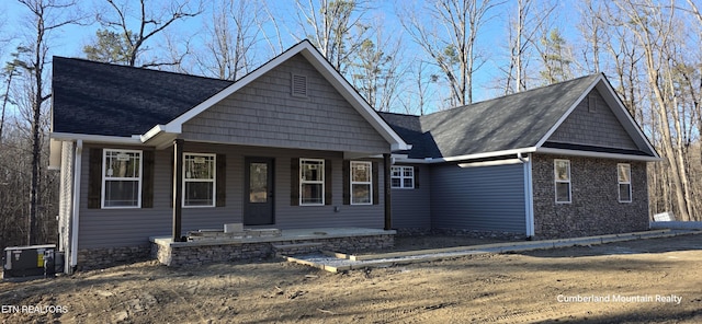 view of front of house featuring covered porch and a shingled roof