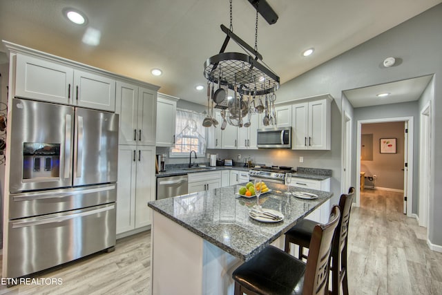 kitchen with white cabinets, a center island, sink, and stainless steel appliances