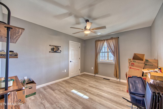 office area with ceiling fan, light wood-type flooring, and a textured ceiling