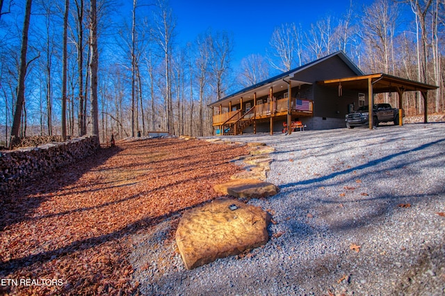 rear view of house with a carport and a wooden deck