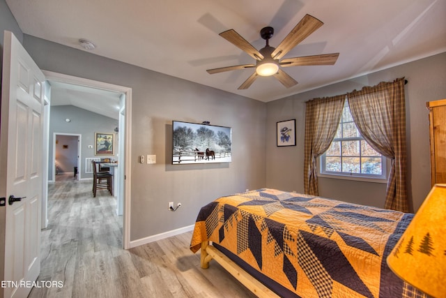 bedroom featuring ceiling fan, light hardwood / wood-style floors, and lofted ceiling